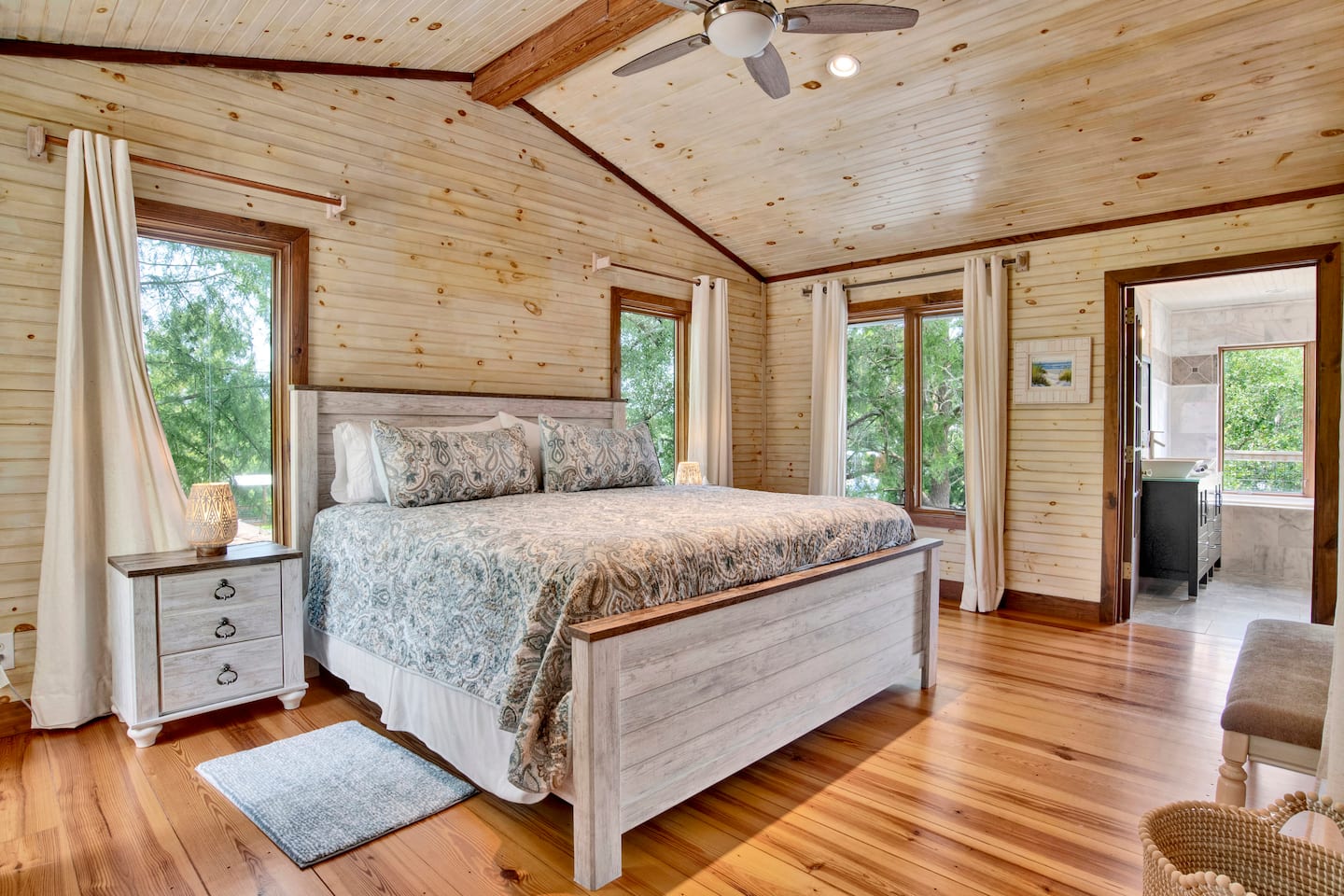 King bedroom with natural wood walls and floors