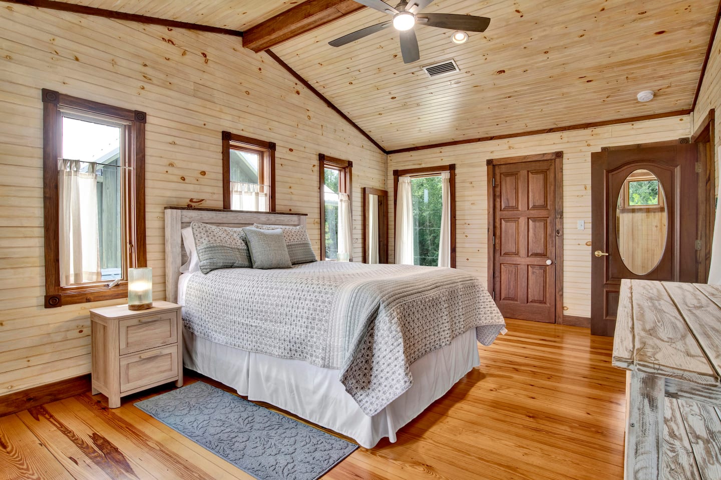 Queen bedroom with natural wood walls and floors